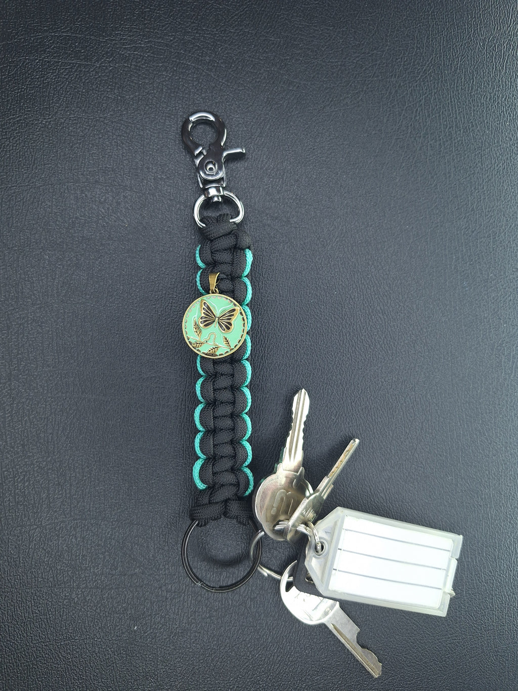 black w/teal paracord keychain with butterfly pendant