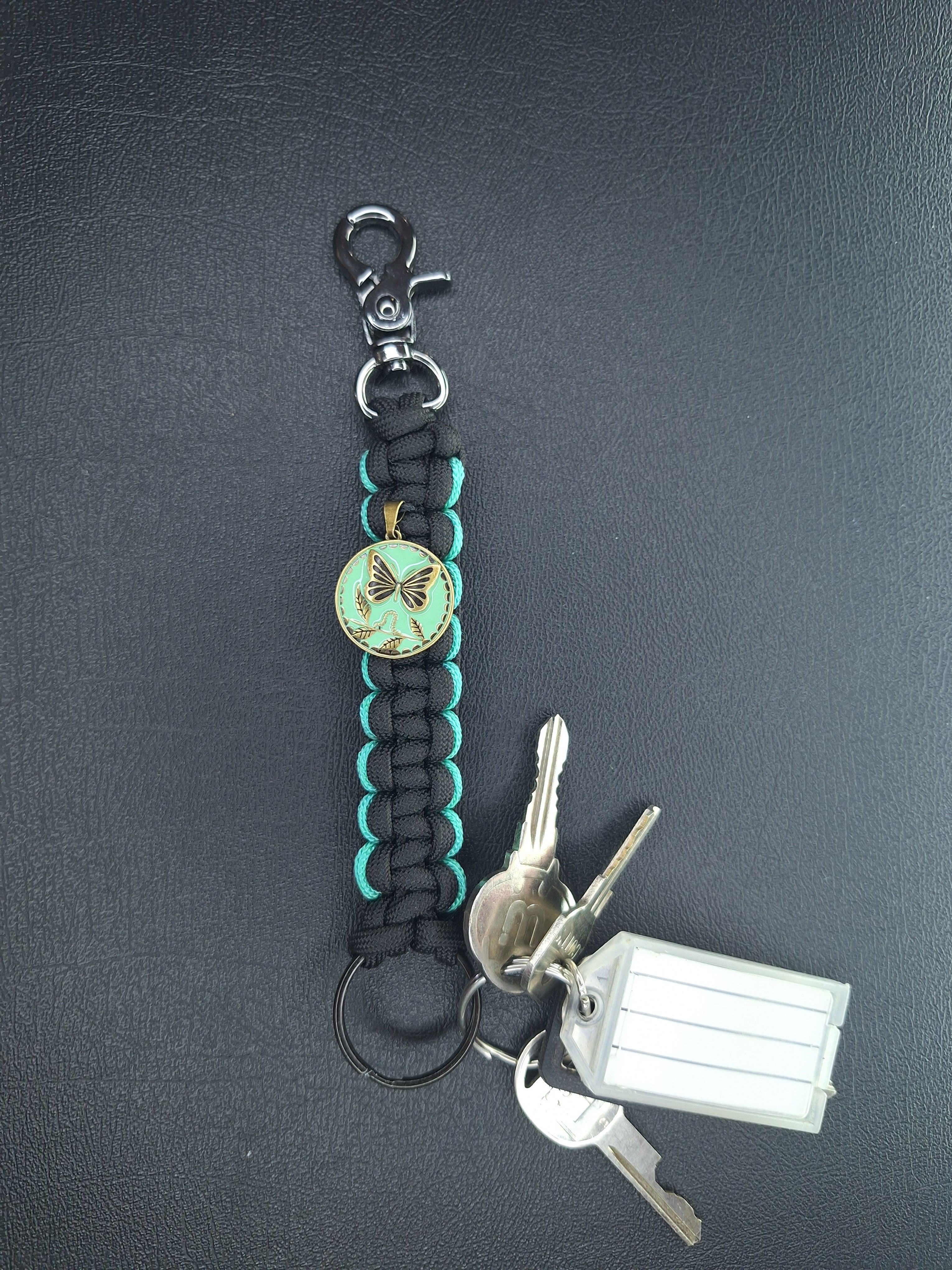 black w/teal paracord keychain with butterfly pendant